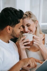 Happy couple sharing a warm moment with coffee indoors, smiling and close.